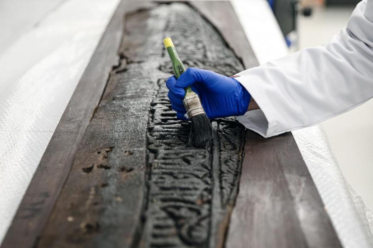 مرمم يعمل على لوح خشبي منحوت في معمل ترميم في المتحف القومي للحضارة المصرية في القاهرة، مصر.