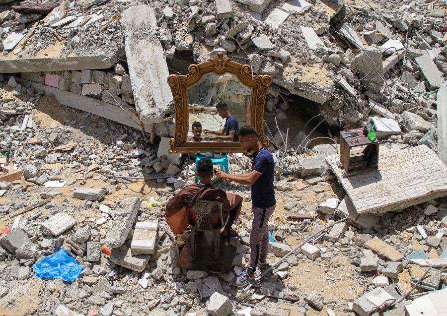 حلاق فلسطيني يستأنف عمله فوق ركام محله المدمر بغارة إسرائيلية على غزة